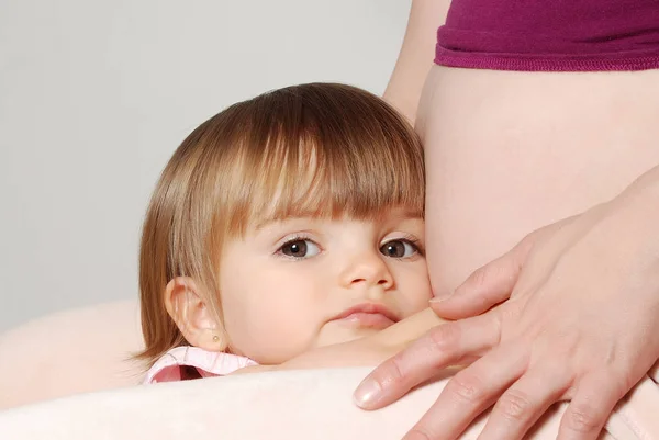 Menina Abraçando Mãe Grávida Fundo Branco — Fotografia de Stock