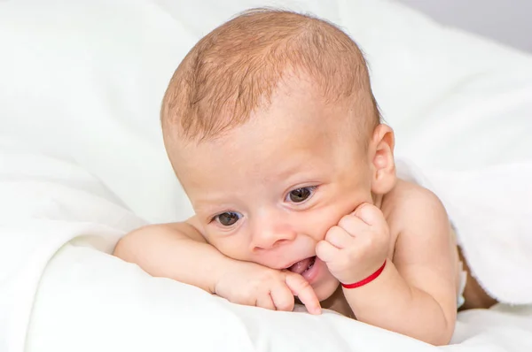 躺在白床单上的初生男婴的肖像 — 图库照片