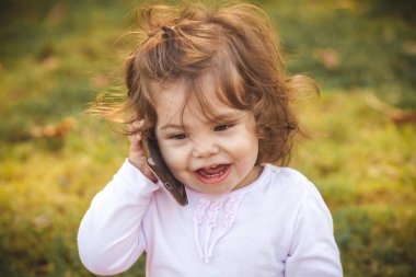 Parkta cep telefonu olan bebek