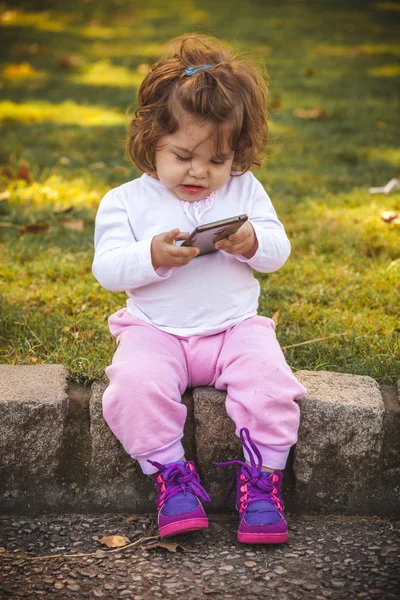 Bebê com celular no parque — Fotografia de Stock