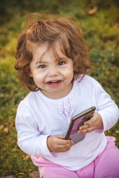 Dítě s mobilním v parku — Stock fotografie