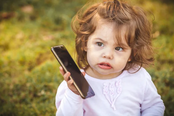 Baby med mobil i parken — Stockfoto