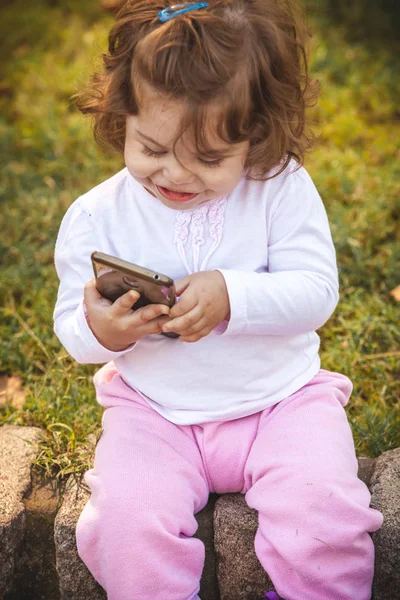 Dítě s mobilním v parku — Stock fotografie