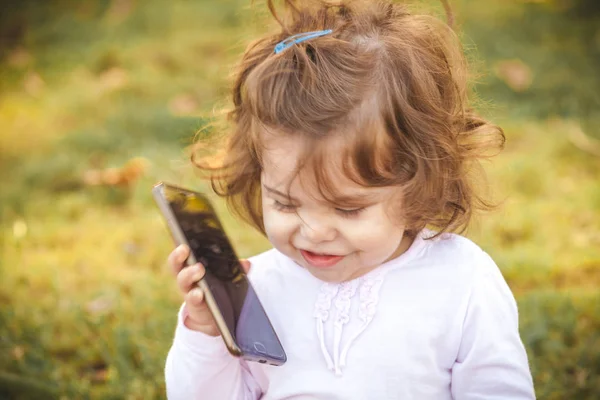 Дитина з мобільним в парку — стокове фото