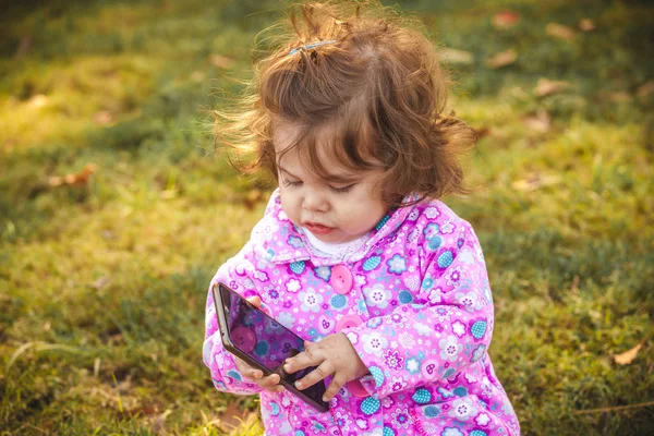 Baby met mobiel in park — Stockfoto