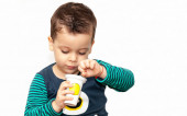kisgyerek eszik joghurt fehér háttér