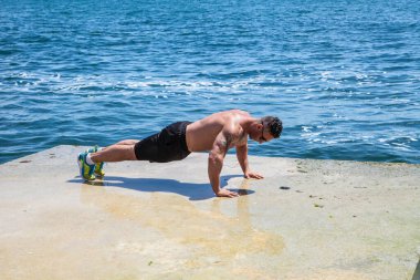 Sahilde egzersiz yapan bir sporcu.