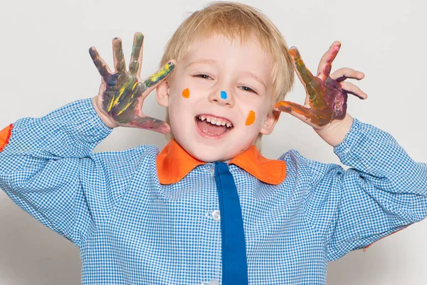 塗料で覆われた小さな男の子面白い顔を作る — ストック写真