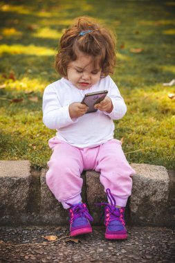 Parkta cep telefonu olan bebek 