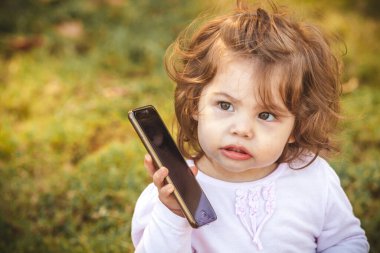 Parkta cep telefonu olan bebek 