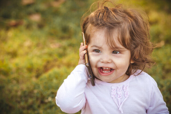 ребенок с мобильным в парке 