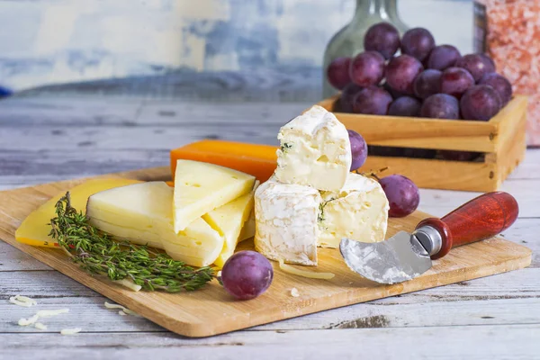 Queso Sabroso Con Las Uvas Sobre Mesa Madera Sobre Tabla —  Fotos de Stock