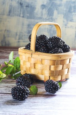 dokulu bir tabloda bir hasır sepet içinde taze böğürtlen yakın çekim
