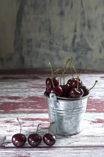 Cherry in bucket on textured background — Stock Photo, Image