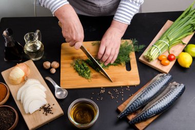 Şef balık pişirmek için sebze keser.