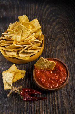 Ahşap masada soslu cips.