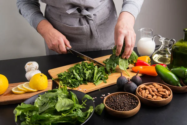 Die Hände Des Chefs Schneiden Spinat Auf Einem Schneidebrett — Stockfoto