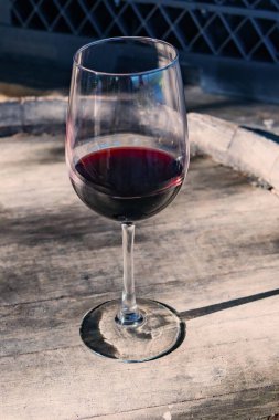 Şaraphanedeki meşe fıçısında duran zarif kırmızı şarap kadehi.