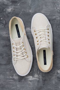 Tommy Hilfiger ayakkabıları şehir ortamında sergilenen dayanıklı tuvaller, temiz bağcıklar ve ince marka ayrıntıları..