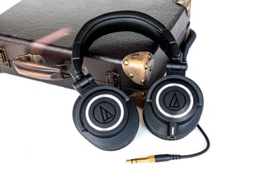 Profesyonel siyah kulaklıklar. Beyaz arka planda altın fişi olan ses teknikleri.