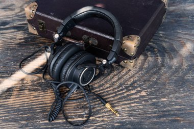 Studio-grade headphones with coiled cable resting on rustic surface High-quality wired audio gear for music lovers and audiophiles in retro setting
