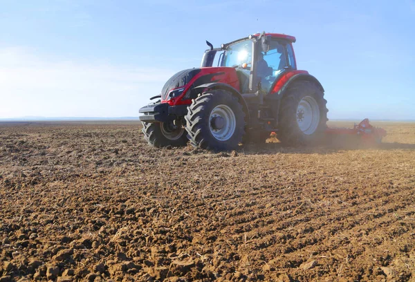 Traktörçiftçi ilkbaharda arazi hazırlıyor — Stok fotoğraf