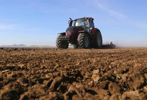 Een boer op een tractor bereidt grond voor inzaai. — Stockfoto