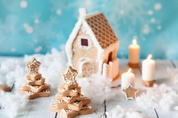 Gingerbread house and gingerbread trees on a festive Christmas background