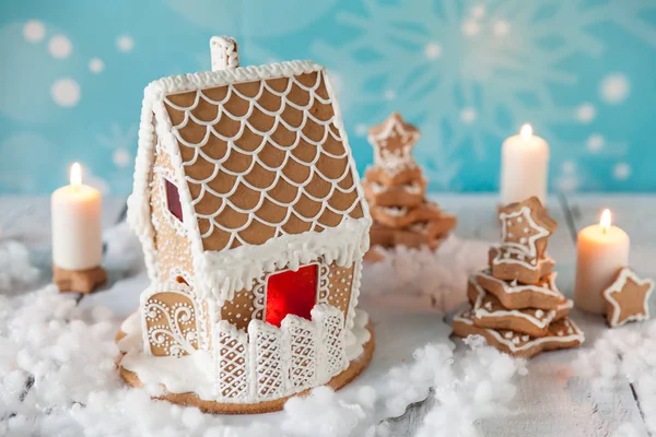 Gingerbread house and gingerbread trees on a festive Christmas background