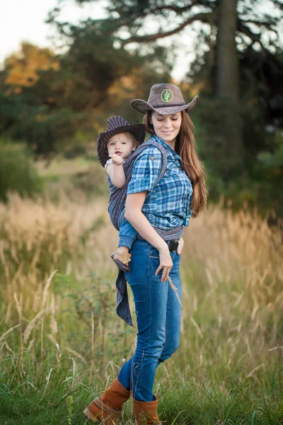 Kovboy kız anne bebek belada küçük kızı taşıyan — Stok fotoğraf