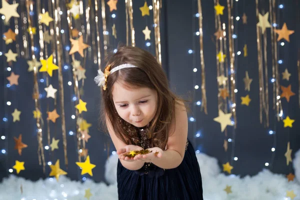 Dívka ve studiu s dekorem zlaté hvězdy — Stock fotografie