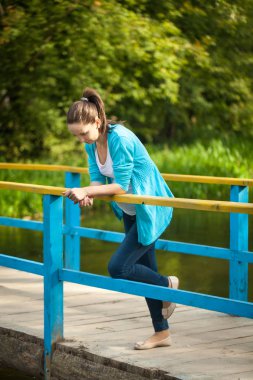 Bir mavi ahşap köprü genç mutlu bir hamile kadın portresi.