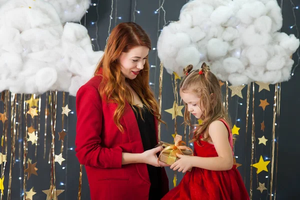 Cute little girl with a mom holding a present