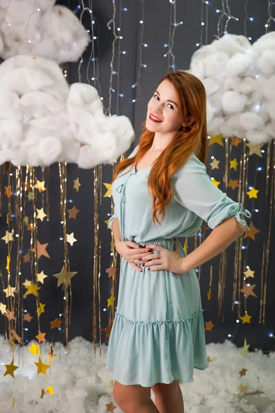 Mujer joven en un estudio con una decoración de estrellas doradas — Foto de Stock