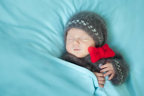 Bebé recién nacido dormido en un traje de hombre de jengibre de ganchillo —  Fotos de Stock