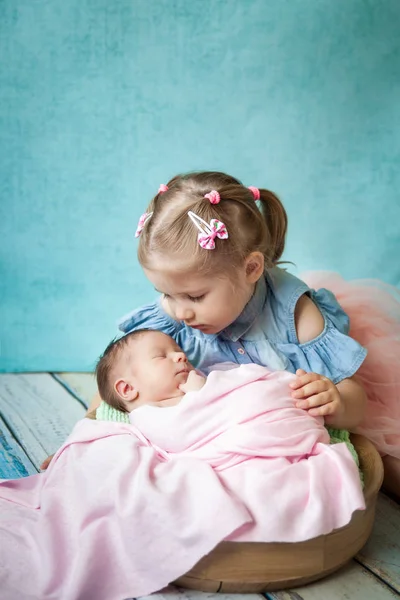 Menina abraçando sua irmã recém-nascida adormecida — Fotografia de Stock