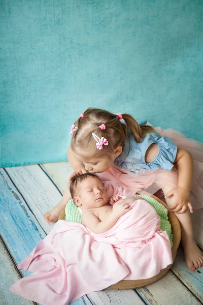 Mädchen umarmt ihre schlafende neugeborene Schwester — Stockfoto