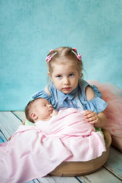 Mädchen umarmt ihre schlafende neugeborene Schwester — Stockfoto