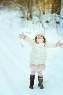 Kış ormanda beyaz kürk paltolu küçük kız
