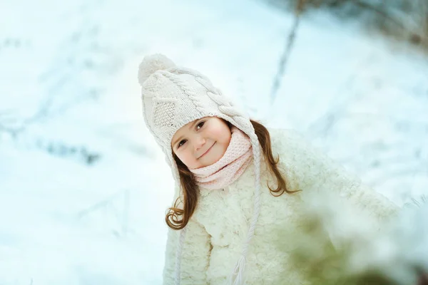 Petite fille en manteau de fourrure blanche dans la forêt d'hiver — Photo