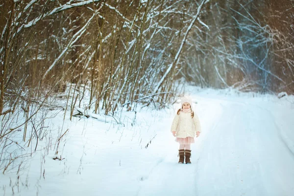 Petite fille en manteau de fourrure blanche dans la forêt d'hiver — Photo