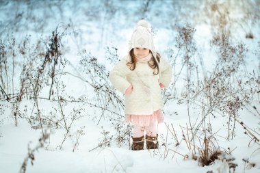 Kış ormanda beyaz kürk paltolu küçük kız