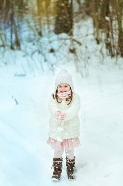 Kış ormanda beyaz kürk paltolu küçük kız