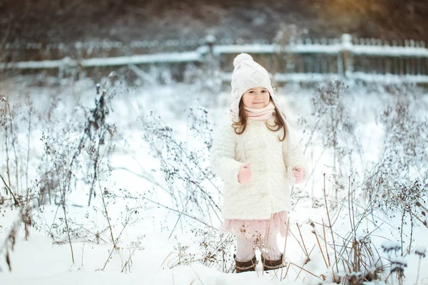 Petite fille en manteau de fourrure blanche dans la forêt d'hiver — Photo