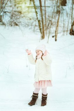 Kış ormanda beyaz kürk paltolu küçük kız