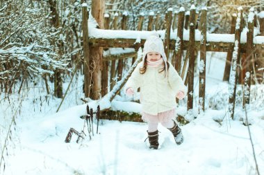 Kış ormanda beyaz kürk paltolu küçük kız