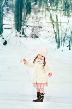 Kış ormanda beyaz kürk paltolu küçük kız