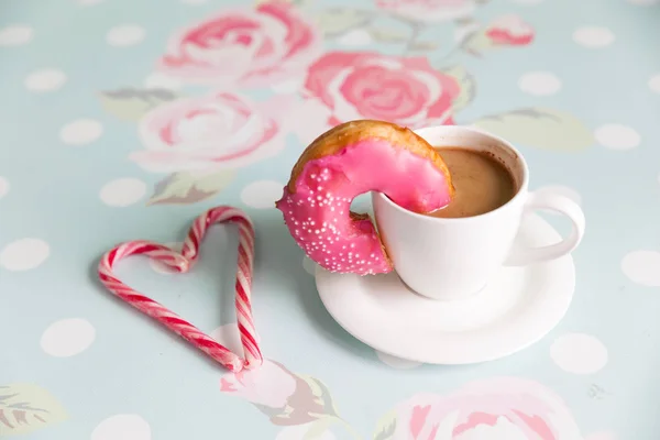 Ντόνατ και καφέ σε φλοράλ φόντο — Φωτογραφία Αρχείου