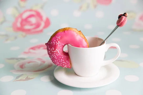 Donut and coffee on floral background — Stock Photo, Image