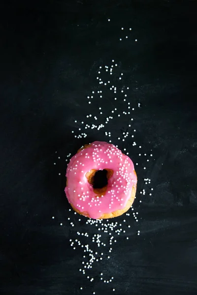 Donut rosa no fundo preto — Fotografia de Stock